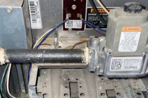 Gas furnace burners and gas valve exposed during a cleaning and tune-up service